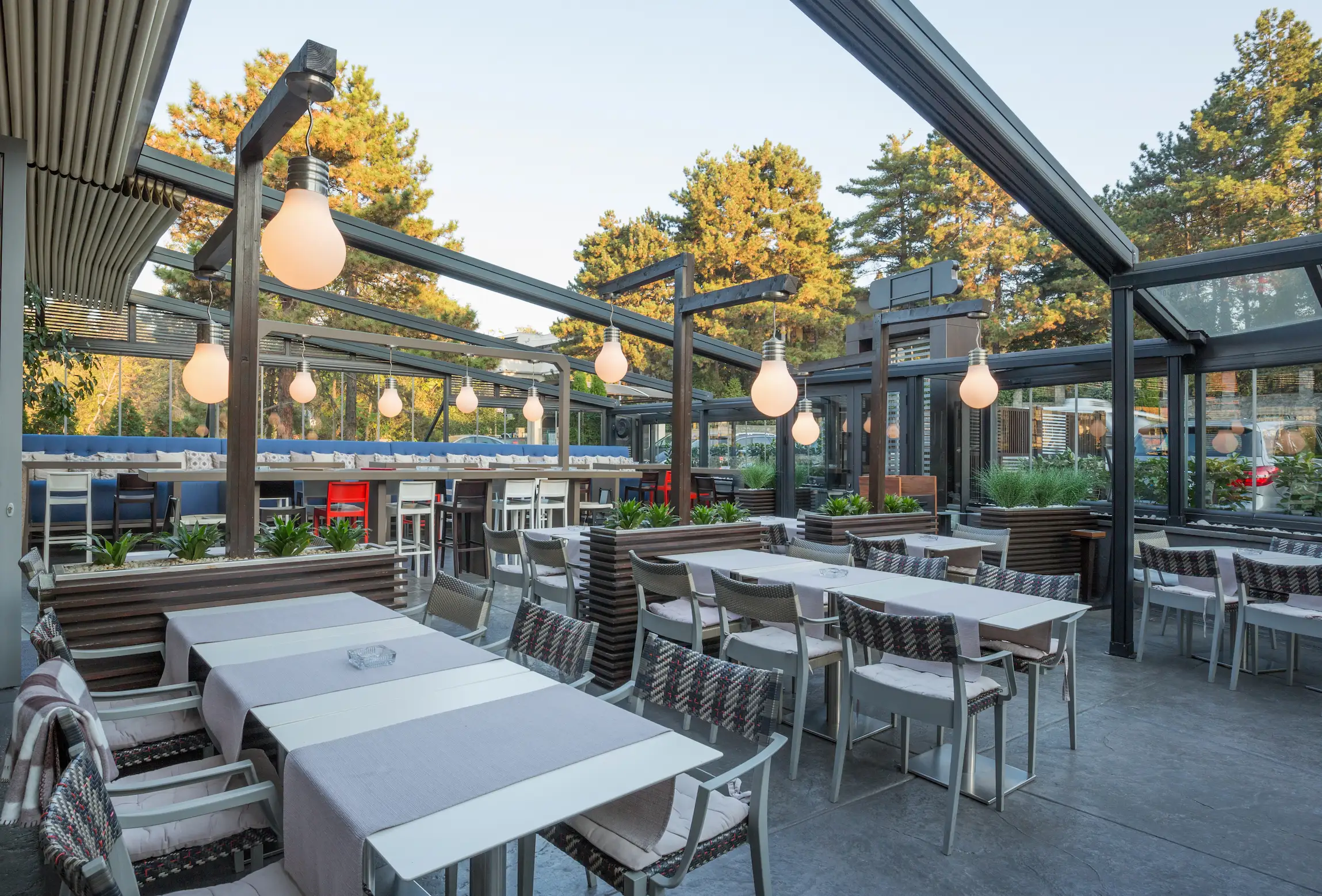 Pergola voor horeca buiten met verlichting en tafels en stoelen